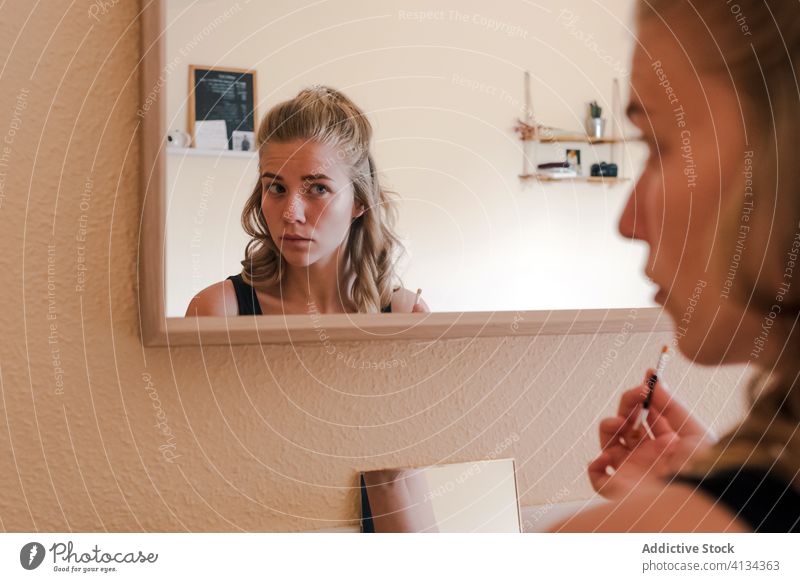 Junge Frau mit Augenbrauenstift beim Schminken Bleistift Make-up Kosmetik bewerben Schönheit Spiegel heimwärts dekorativ lässig Umrisslinie jung richtig Pflege