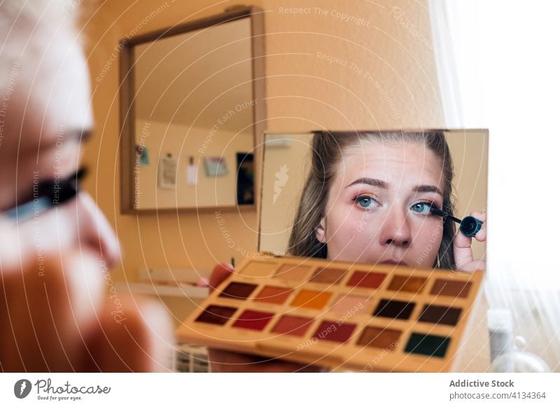 Junge Frau trägt Wimperntusche auf Make-up Kosmetik bewerben Schönheit Spiegel heimwärts dekorativ Palette Lidschatten lässig jung Pflege Routine Vorschein Auge