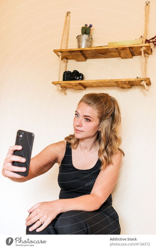 Junge Frau benutzt zu Hause ein Mobiltelefon Smartphone heimwärts benutzend jung lässig Telefon positiv Apparatur Mobile Internet Kommunizieren Gerät Anschluss