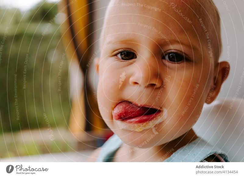 Bezauberndes Kleinkind isst leckeres Eis essen Stieleis dreckig Mund Speiseeis Kind genießen geschmackvoll selbstgemacht Sommer bezaubernd Leckerbissen Terrasse
