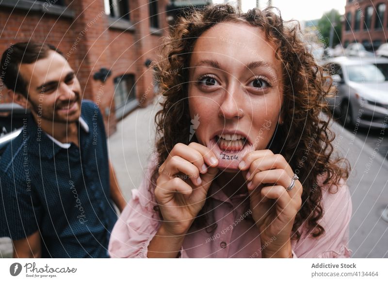 Ausdrucksstarke Frau mit Tattoo auf den Lippen expressiv Großstadt manifestieren Freund Paar Zusammensein New York State amerika Vereinigte Staaten USA Lächeln