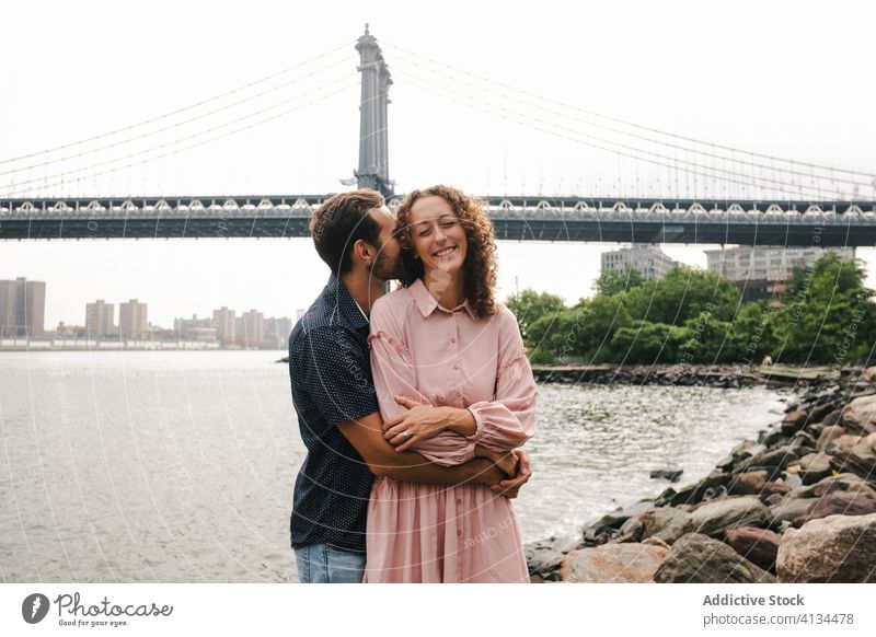 Ehepaar auf Steinen in der Nähe des Flusses Freundin Paar Umarmen Zusammensein Partnerschaft Brooklyn Bridge romantisch Umarmung New York State amerika