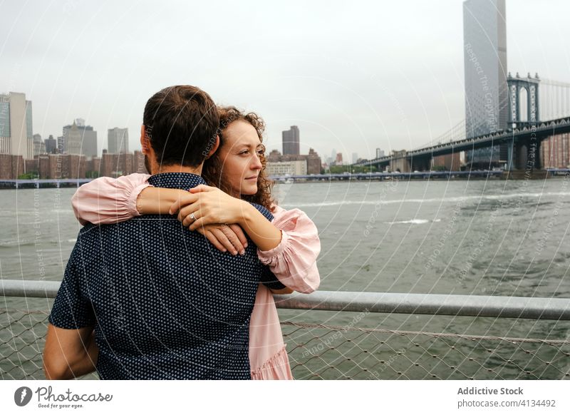 Glückliches Paar umarmt sich am Damm Umarmen Spazierweg schlendern Großstadt Stauanlage Partnerschaft Fluss Umarmung Brooklyn Bridge New York State amerika