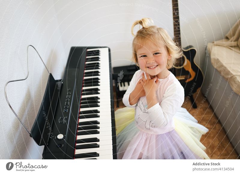 Süßes Mädchen lernt modernes Klavierspielen lernen heimwärts Synthesizer Kindheit niedlich Musik Glück Lächeln Klasse Rock Schulmädchen Bildung üben vorbereiten