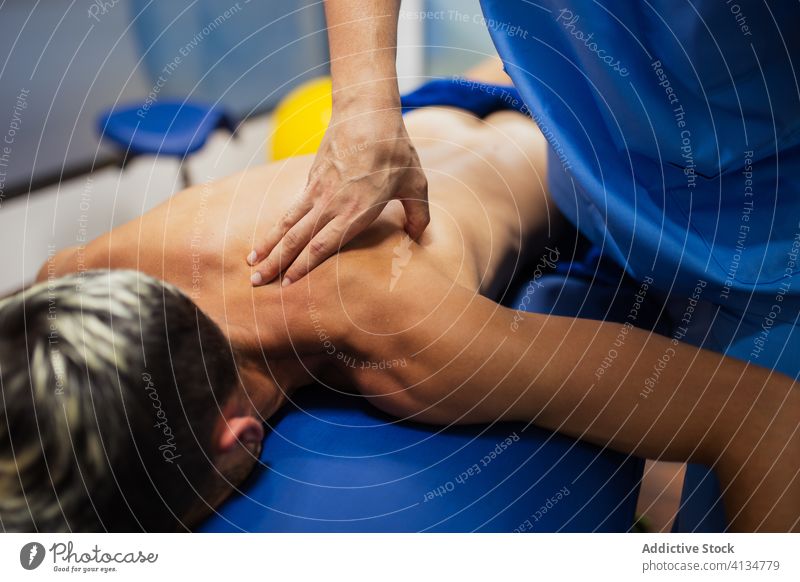 Orthopäde massiert den Rücken eines Sportlers während einer ärztlichen Untersuchung geduldig Wiederherstellung untersuchen professionell Osteopathie