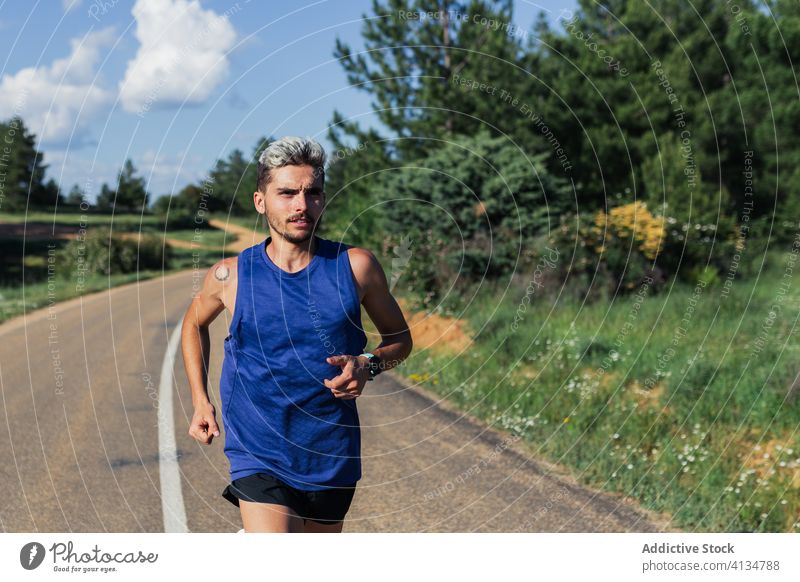 Entschlossener Mann läuft während des Trainings auf der Straße laufen schnell Übung Fitness jung Sport passen Aktivität Sportbekleidung joggen urban Gesundheit