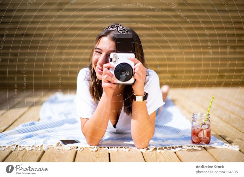 Fröhliche Frau beim Fotografieren fotografieren Sommer heiter sofort Fotoapparat Glück jung positiv sonnig Terrasse ruhen Lifestyle Urlaub Feiertag Lächeln