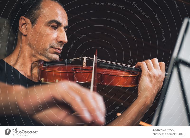 Ethnischer männlicher Musiker, der Geige spielt spielen Instrument Mann Talent Schot Geiger Melodie ethnisch hispanisch ausführen Probe Klang unterhalten Hobby