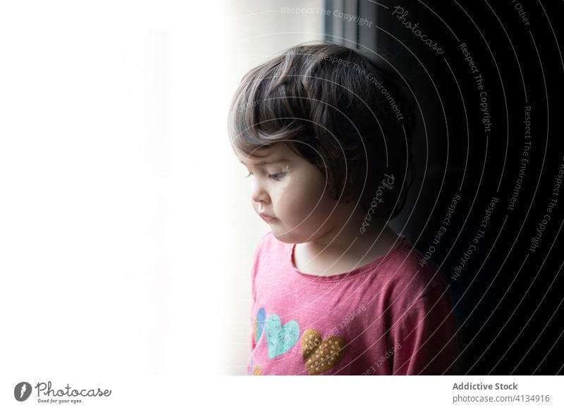 Trauriges Kind steht am Fenster heimwärts traurig Mädchen einsam unglücklich nachdenklich besinnlich Windstille verärgert Kindheit ruhig Einsamkeit allein