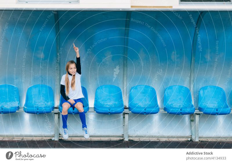 junge Spielerin, die sich im Fußballstadion auf einem Stuhl ausruht Mädchen Stadion Sitz Beschluss u. Urteil lose Uniform Frau Athlet Sport Junior sportlich
