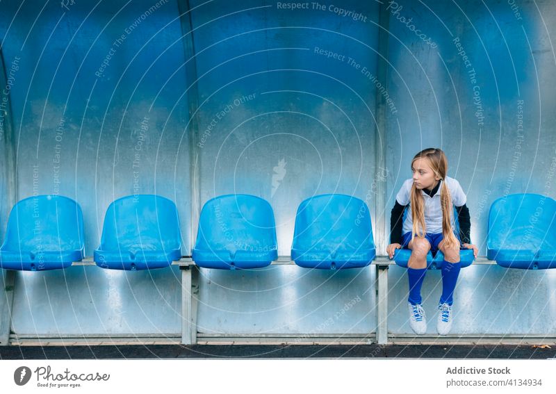 Unglückliche disqualifizierte junge Spielerin ruht sich auf einem Stuhl im Fußballstadion aus Mädchen Stadion verlieren frustrieren Sitz Versagen unglücklich