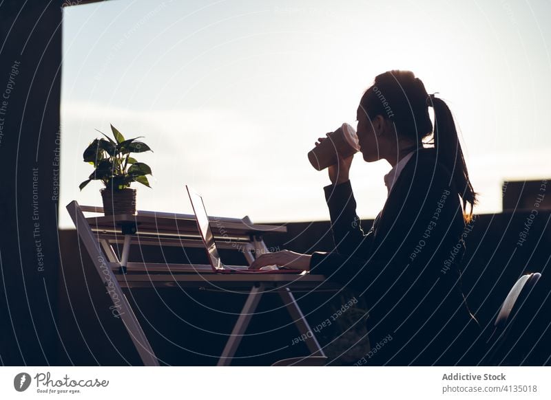 Junge Frau mit Laptop trinkt Kaffee auf dem Dach Arbeit Pause trinken Dachterrasse beschäftigt besinnlich Unternehmer abgelegen asiatisch jung formal Imbissbude