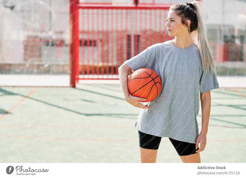 Selbstbewusster Basketballspieler auf dem Spielplatz stehend Frau selbstbewusst Sport Gericht wettbewerbsfähig ernst jung Sportlerin Ball Athlet Sportbekleidung