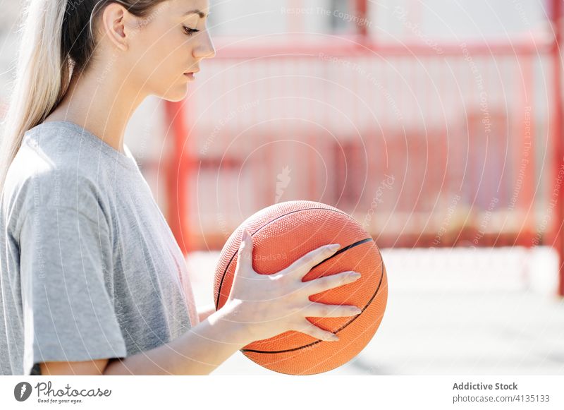 Selbstbewusster Basketballspieler auf dem Spielplatz stehend Frau selbstbewusst Sport Gericht wettbewerbsfähig ernst jung Sportlerin Ball Athlet Sportbekleidung