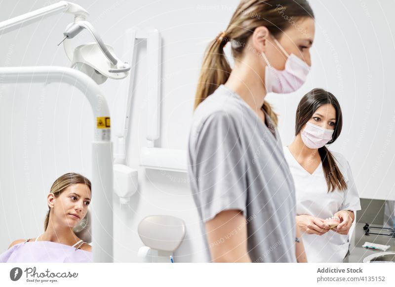 Glückliche Frau während eines Termins in einer Zahnklinik Frauen geduldig Zahnarzt Klinik Ernennung Lächeln Assistent modern besuchen prüfen heiter Stuhl dental