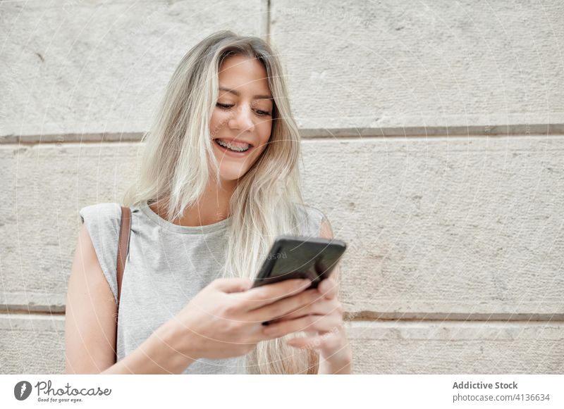 Frau mit Smartphone auf der Straße stehend Großstadt benutzend jung Glück Stil Nachricht Browsen Handy Lifestyle Gerät Apparatur urban Lächeln trendy