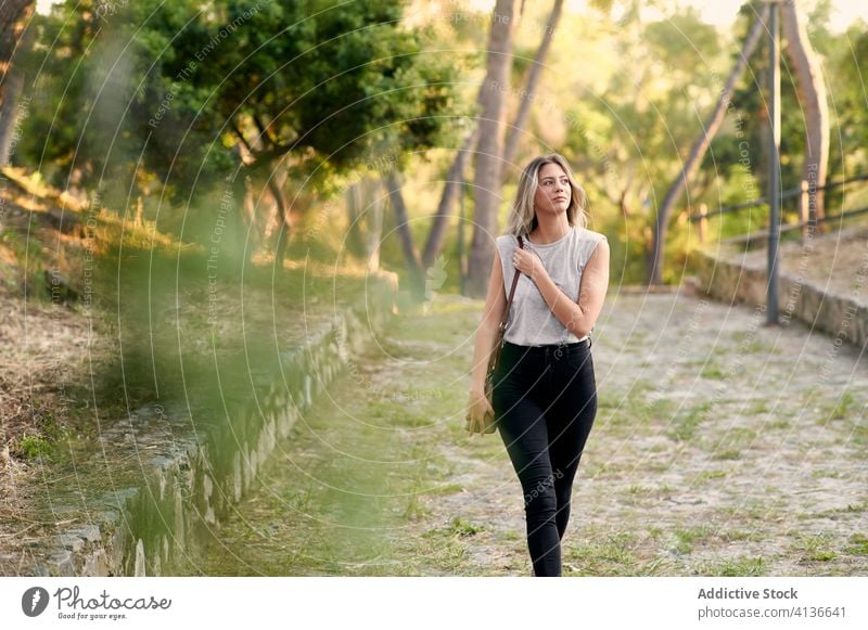 Junge Frau spaziert im grünen Park Spaziergang Sommer Windstille selbstbewusst jung genießen schlendern sich[Akk] entspannen Weg Lifestyle ruhig Natur friedlich