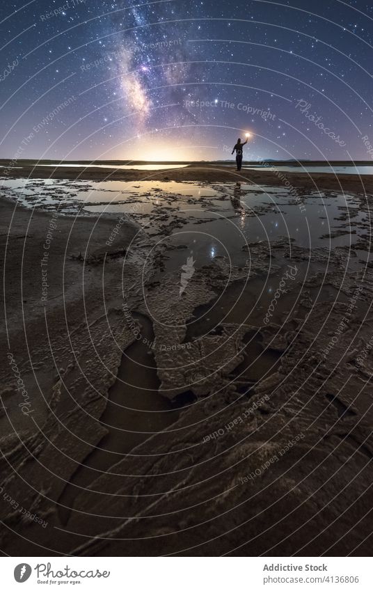 Silhouette eines Mannes an einsamer Küste in sternenklarer Nacht Natur sich[Akk] melden Stern Himmel Milchstrasse stehen Ufer Wunsch fangen Sternschnuppe Fackel
