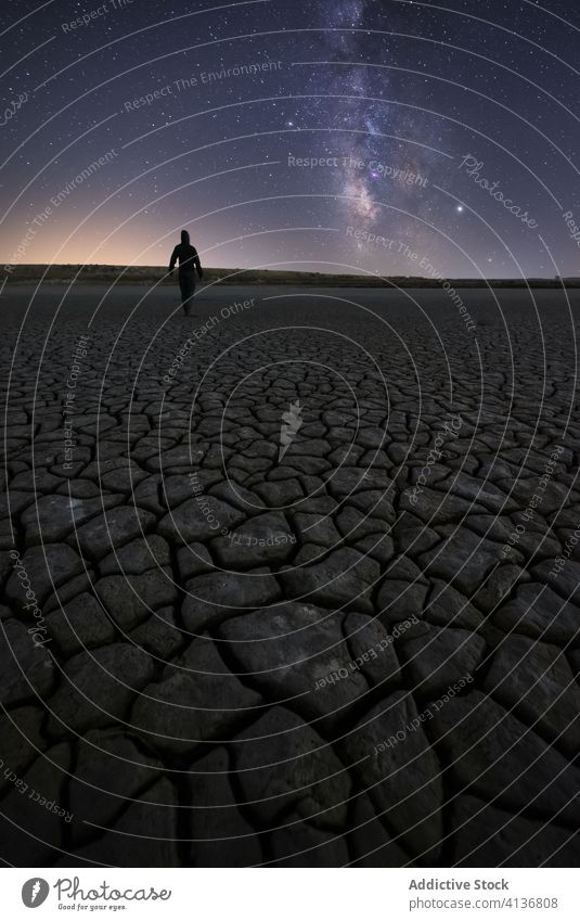 Anonymes Männchen stehend in trockener Wüste in sternenklarer Nacht Mann Himmel Stern Milchstrasse Dürre wüst Silhouette Natur Oberfläche trocknen Riss