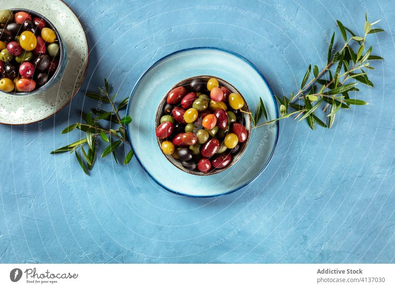 Oliven. Eine Vielzahl von grünen, schwarzen und roten Oliven mit Blättern, von oben geschossen Kalamata braun Varieté Sortiment Overhead Antipasti Ansicht Top