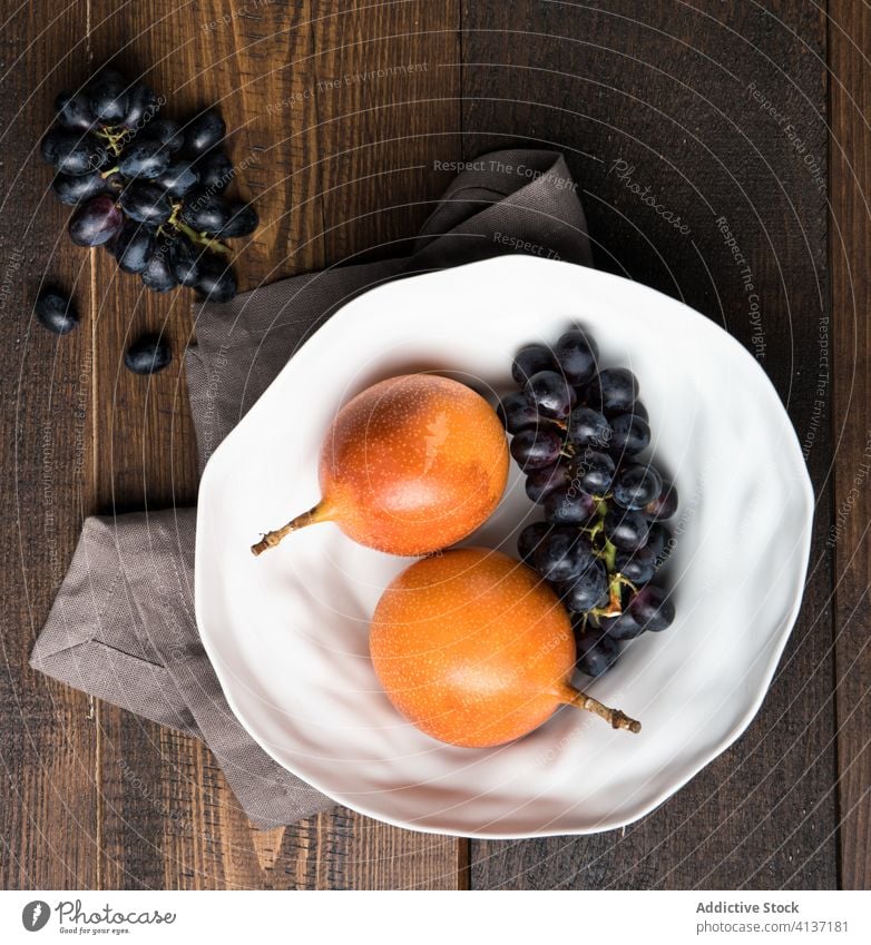 Frische Passionsfrüchte und Weintrauben im Teller Frucht Traube exotisch Passionsfrucht frisch Vitamin Küche Tisch natürlich roh Haufen gesunde Ernährung