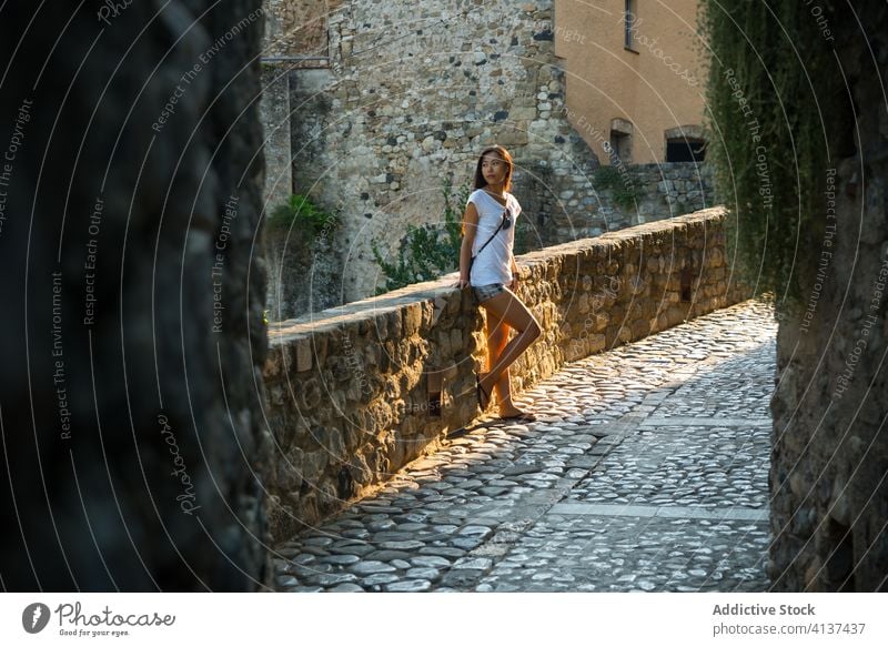 Junge Frau steht auf einer alten Steinbrücke reisen mittelalterlich Kopfsteinpflaster Gebäude Brücke Straße antik Stadt Spanien Bestwert Architektur jung