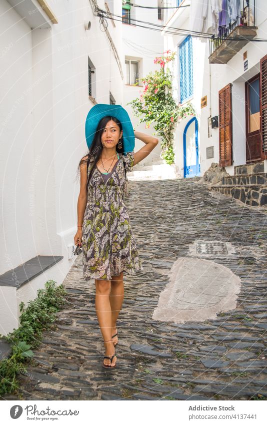 Ethnische Frau geht auf der Straße der alten Stadt reisen mittelalterlich Architektur Stein eng Spaziergang jung asiatisch ethnisch Sommer Stil elegant Cadaques