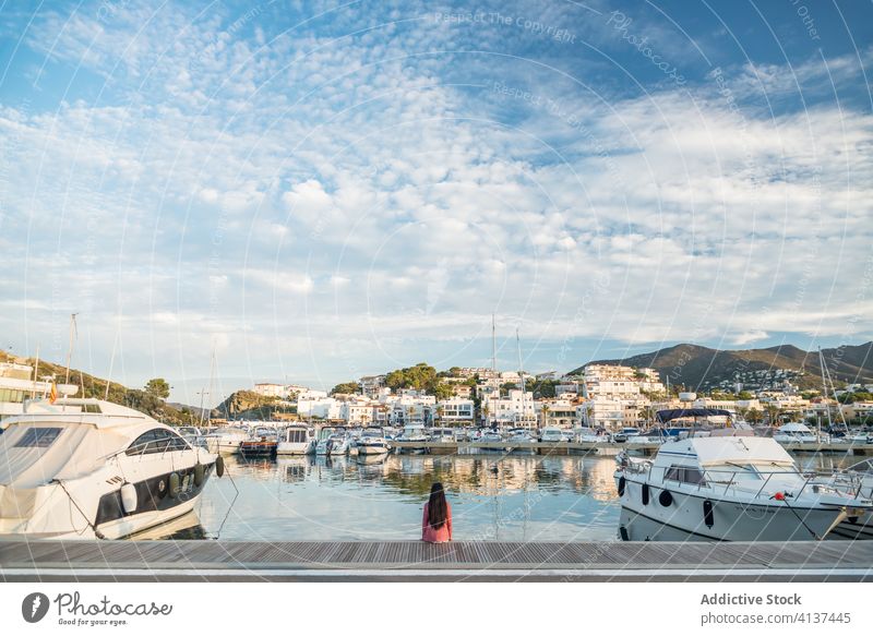 Anonyme Frau sitzt im Hafen einer Küstenstadt Pier Portwein Stadt reisen Gefäße malerisch Küstenlinie MEER Meeresufer llanca Spanien Wasser
