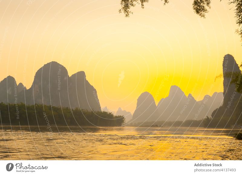 Ruhige Landschaft mit Fluss und Felsen bei Sonnenuntergang erstaunlich Silhouette Berge u. Gebirge Abend Rippeln hell Dämmerung Natur Yangshuo Bezirk Yangshuo