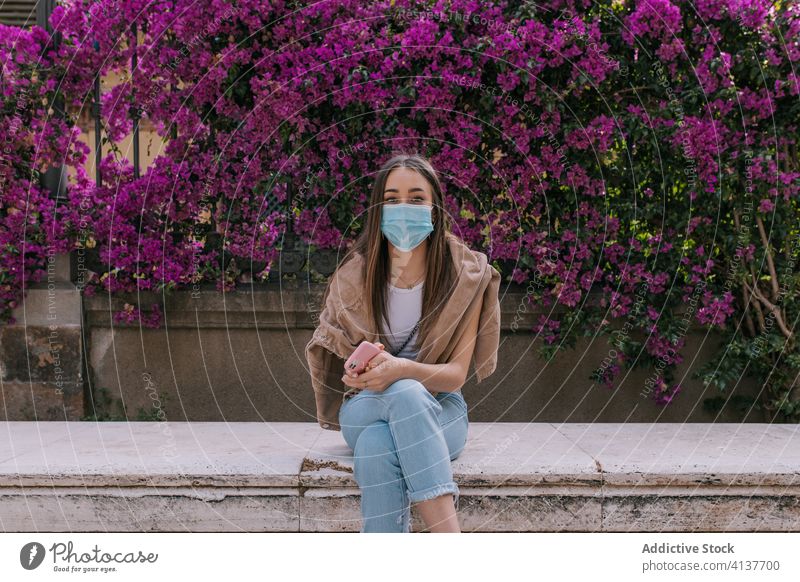 Junge Frau trägt während einer Pandemie eine Gesichtsmaske im Freien Straße Mundschutz Korona Virus Schutz jung Großstadt Person Krise beunruhigt Entfernung