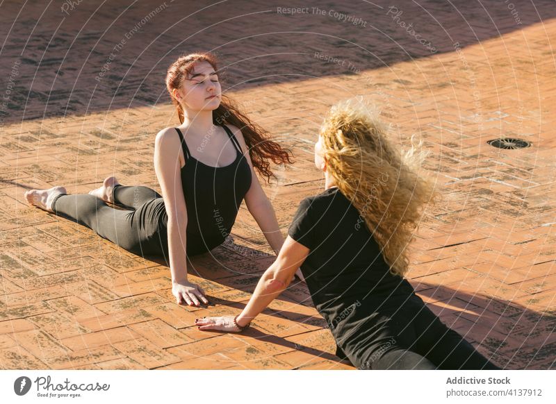 Flexible Frauen üben Yoga Rückenbeuge Asana auf Terrasse Zusammensein Pose positionieren Kobra bhujangasana Rückbiegung anfällig beweglich Gleichgewicht Dehnung