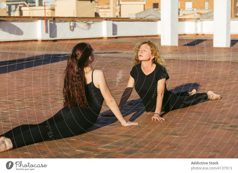Flexible Frauen üben Yoga Rückenbeuge Asana auf Terrasse Zusammensein Pose positionieren Kobra bhujangasana Rückbiegung anfällig beweglich Gleichgewicht Dehnung