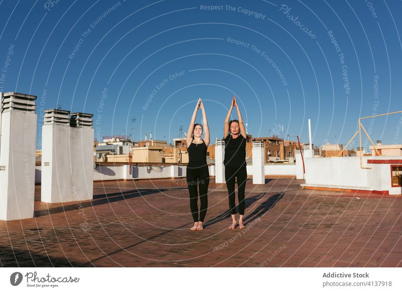 Frauen beim Sonnengruß während der Yoga-Praxis Zusammensein üben Aufwärtssalto urdhva hastasana Pose stehen Dachterrasse positionieren Dehnung Gleichgewicht