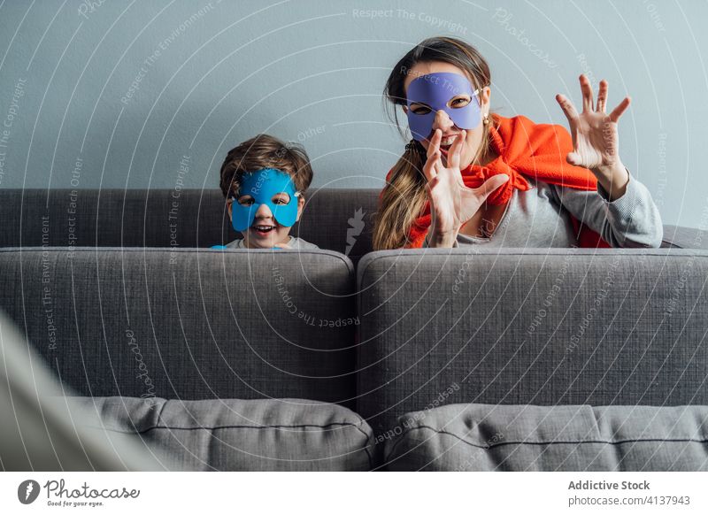 Kreative Mutter und Sohn in Superheldenmasken zu Hause spielen Mundschutz Spiel kreativ so tun, als ob Spaß haben spielerisch heiter wenig Wochenende Junge Kind