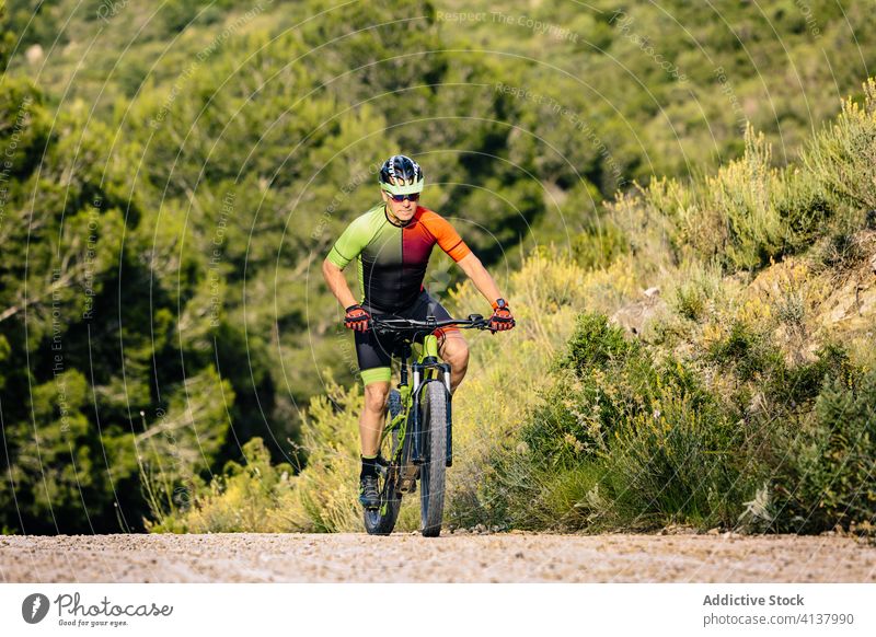 Mann mit Helm fährt Mountainbike im Wald Fahrrad Mitfahrgelegenheit Stein Herbst extrem Schutzhelm Sport Natur Adrenalin Lifestyle Landschaft Abenteuer