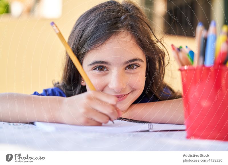 Kleines Mädchen zeichnet mit Buntstiften zeichnen Bleistift positiv Lächeln Kind kreativ Kindheit Hobby Aktivität Freizeit Glück Schulmädchen freundlich wenig