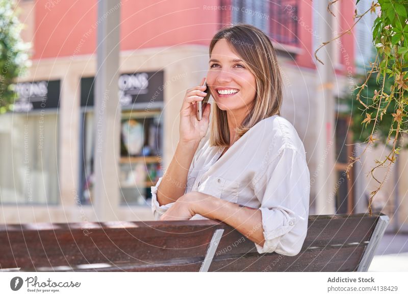 Stilvolle Frau mit Handy chillen auf Bank im Sommer Tag Smartphone Lifestyle benutzend Texten modern Kälte ruhen Gerät Apparatur Anschluss Mobile Kommunizieren