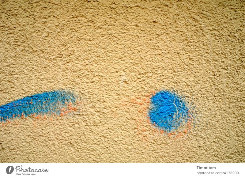 Eine augenzwinkernde Fassade (Teilansicht) Rauhputz Wand Putz Haus Farbe ocker blau orange fröhlich Menschenleer