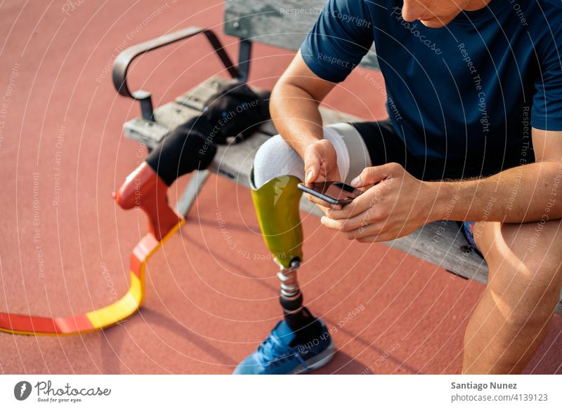 Behinderter Sportler beim Telefonieren per Telefon Mann Läufer Athlet unerkannt gesichtslos Prothesen Prothetik Behinderung deaktiviert Amputation Amputierte