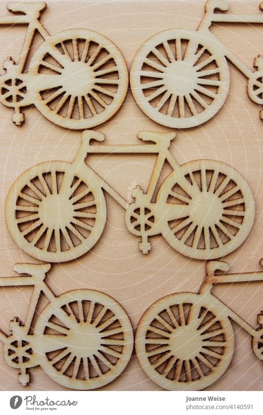 Ausgeschnittene Fahrräder aus Holz auf einem Holzhintergrund. Fahrrad Wagenräder Verkehr Fahrradfahren Radfahren Fahrradtour Transport Mitfahrgelegenheit Zyklus