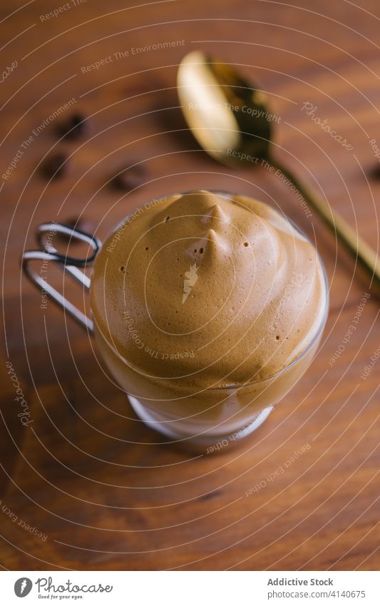 Dalgona Kaffee und Kaffeebohnen im Holztisch dalgona-kaffee gepeitscht melken geschmackvoll kalt Bohnen Erfrischung Kaffeelöffel Tisch trinken sofort hinzufügen