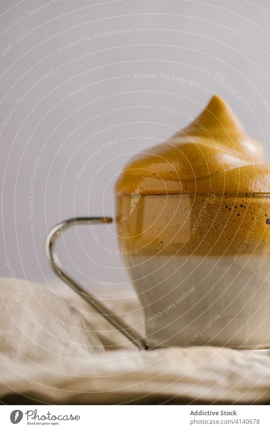 Dalgona Kaffee in weißer Serviette dalgona-kaffee gepeitscht melken geschmackvoll kalt Erfrischung Kaffeelöffel trinken sofort hinzufügen lecker Glas Getränk