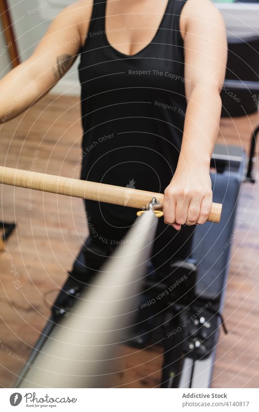 Starker Sportler an der Pilates-Maschine Reformer Training Übung Fitnessstudio passen männlich Athlet hölzern Bar Zeitgenosse Gesundheit muskulös stark Wellness