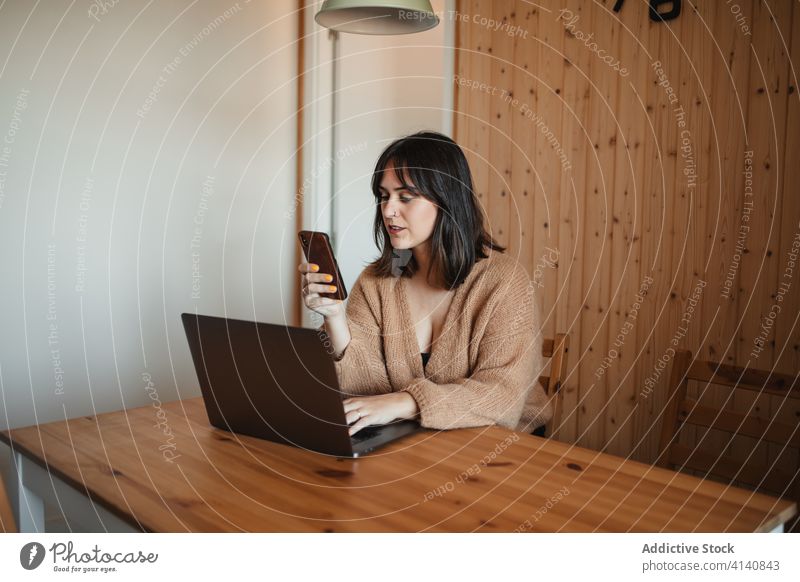 Vielbeschäftigte Unternehmerin beim Surfen auf dem Handy zu Hause Geschäftsfrau Smartphone abgelegen Arbeit benutzend Nachricht Browsen freiberuflich heimwärts
