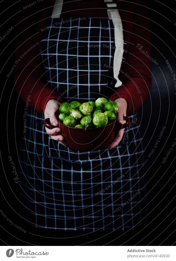Crop-Frau mit Schüssel Rosenkohl Schalen & Schüsseln Koch Schürze frisch Hausfrau Küche Kohlgewächse organisch Vegetarier Bestandteil Gesundheit Gemüse