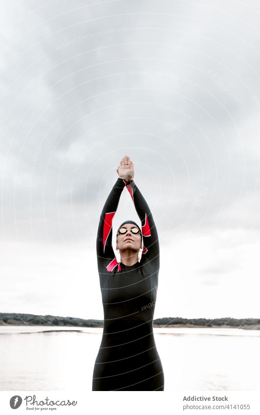 Frau im Taucheranzug mit Brille am Seeufer Neoprenanzug Schutzbrille Badeanzug Ufer extrem Umwelt Schwimmer aqua sportlich reisen Bestimmen Sie schwimmen