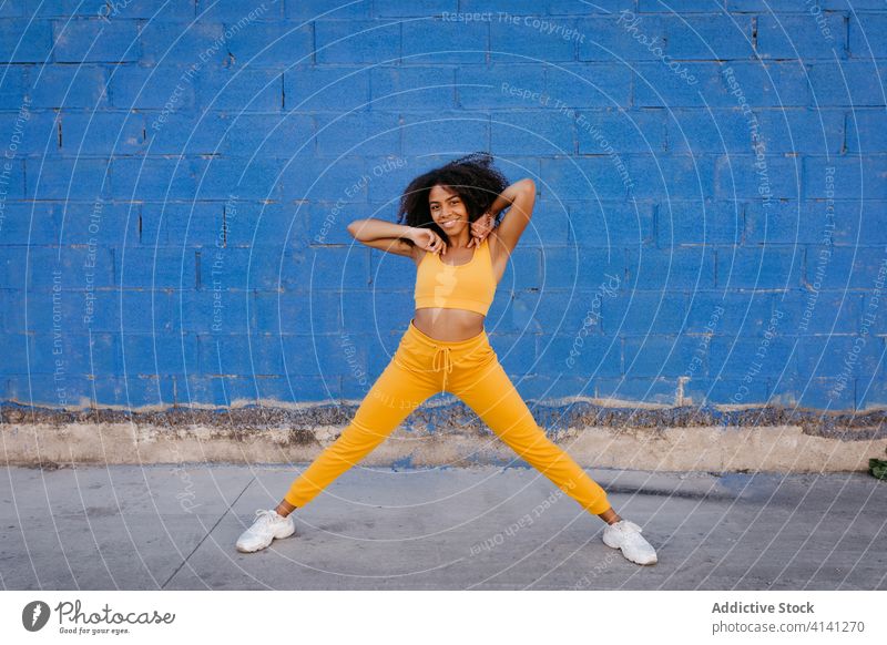 Fröhliche afroamerikanische Frau mit Afro-Frisur in Tanzpose Tanzen Pose sich[Akk] bewegen lebhaft pulsierend heiter Lächeln Bewegung Farbe schwarz ethnisch