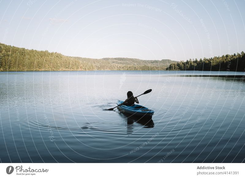 Unbekannte Frau rudert Boot auf Fluss Reihe Kajak reisen Ruder Silhouette wolkenlos Nationalpark la mauricie Quebec Kanada Ausflug Windstille See Gelassenheit