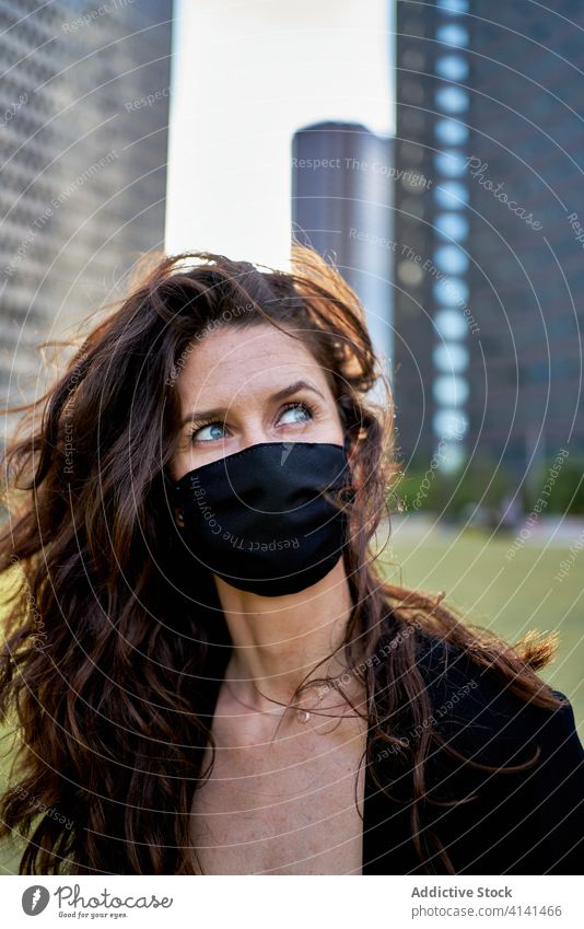 Seriöse Frau mit medizinischer Maske in der Stadt Seuche Coronavirus Mundschutz Großstadt Bund 19 behüten verhindern Sicherheit Stadtzentrum ernst modern