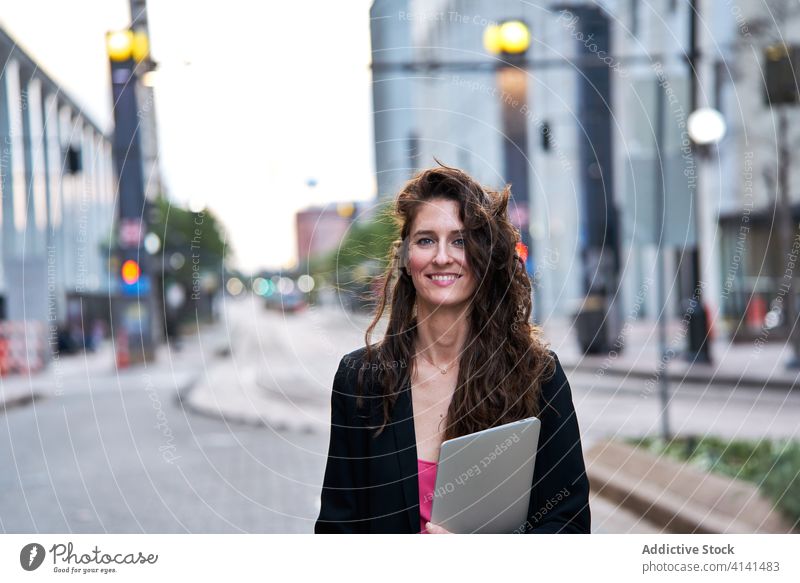 Geschäftsfrau mit Laptop auf der Straße in der Stadt Unternehmer Großstadt selbstbewusst Stadtbild formal gut gekleidet professionell Frau Business heiter